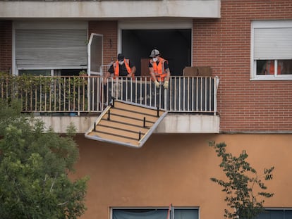 Un trabajador saca un canapé por el balcón durante el desalojo de 62 familias en Alcobendas, Madrid (España).