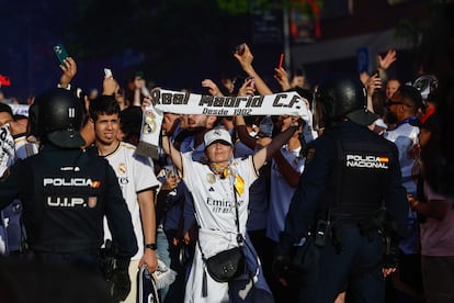 Cientos de personas reciben el autobús del Real Madrid en las inmediaciones del estadio Santiago Bernabéu.