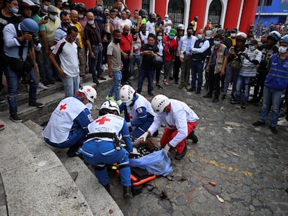 La Cruz Roja colombiana recoge el cadáver del funcionario de la Fiscalía linchado tras disparar contra dos manifestantes.