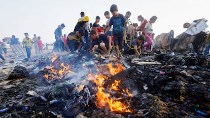 Varios jóvenes buscan comida entre las llamas provocadas por un bombardeo israelí sobre Rafah, en Gaza.