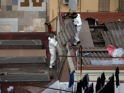 Dos operarios retiran un tejado de amianto en una vivienda en Barcelona, en 2022.