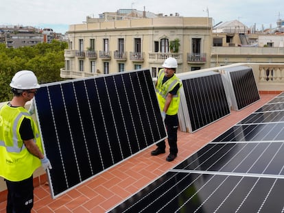 Dos operarios, en una instalación de paneles fotovoltaicos, en Barcelona.
