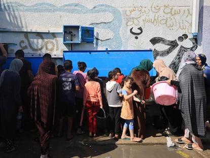 Gazatíes acudían el viernes a un punto de suministro de agua dentro de un campamento para refugiados de la ONU en Jan Yunis, franja de Gaza.