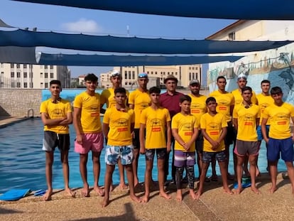 El más importante equipo de natación de Gaza, junto a su entrenador Amjed Tantish (centro), en la piscina en la que entrenaban en Yabalia, al norte de la Franja, en julio de 2023, en una imagen cedida por la familia Tantish.