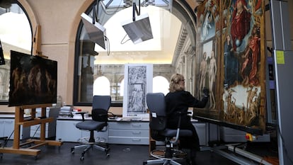 Una mujer trabaja en el taller de restauración del Museo del Prado restaurando las puertas de 'El tríptico de la redención'.