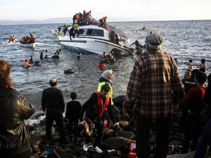 Residentes de la isla griega de Lesbos ayudan a unos refugiados a desembarcar. 