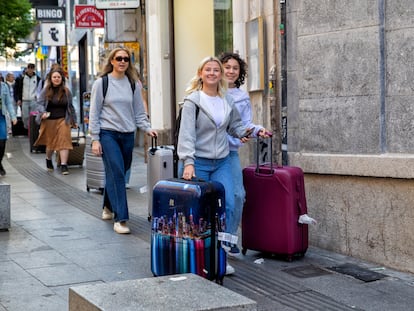 Turistas con maletas por la calle Carretas de Madrid.