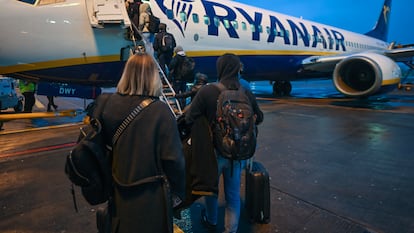 Un grupo de pasajeros sube, con equipaje de mano, a un avión de Ryanair en el aeropuerto de Dublín (Irlanda).