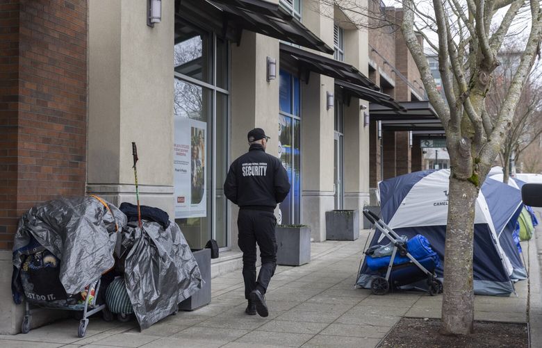 A security guard from Burien City Hall walks past  tents along 5th Ave. SW and SW 152nd St. Monday, March 11, 2024 Monday, March 11, 2024.  People were only allowed to camp there from 7 p.m. until 6 a.m. but Monday things changed and currently they can camp on the sidewalk 24 hours a day.  

King County will be announcing more news today related to Burien’s recently tightened camping law.

 226407