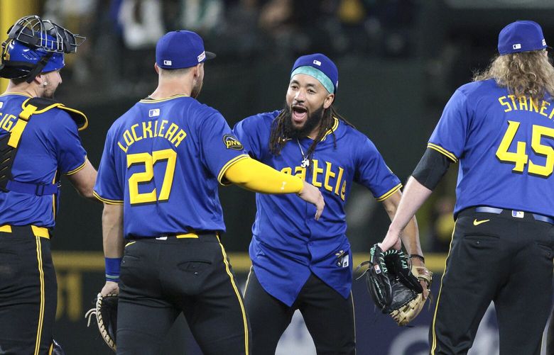 Seattle Mariners’ Cal Raleigh, Tyler Locklear, J.P. Crawford, Ryne Stanek, Dylan Moore and Josh Rojas, from left, celebrate after a baseball game against the Texas Rangers, Friday, June 14, 2024, in Seattle. The Mariners won 3-2. (AP Photo/Jason Redmond) WAJR125 WAJR125