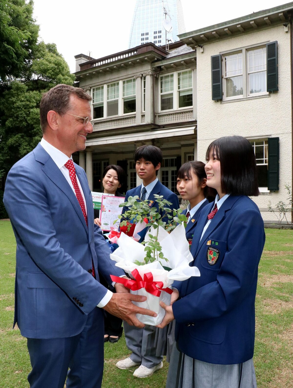 ペータス臨時代理大使（左端）にアンネのバラを贈る右から平田さん、西さん、金森さん