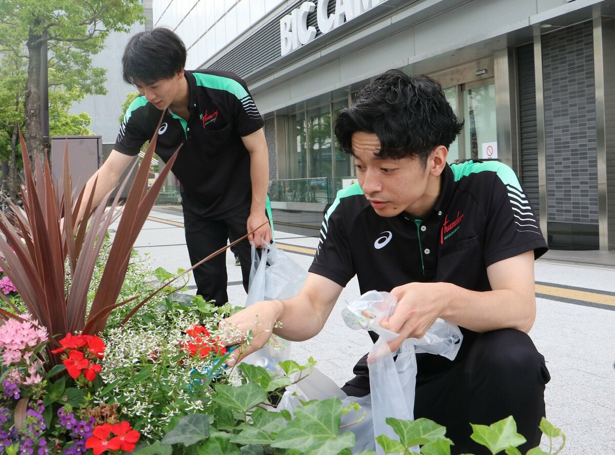 植え込みに捨てられたごみを集める西村選手㊧と井上慎一朗選手