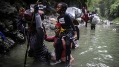 Haitian migrants wade through water as they cross the Darien Gap from Colombia to Panama in hopes of reaching the U.S., Tuesday, May 9, 2023. Pandemic-related U.S. asylum restrictions, known as Title 42, are to expire Thursday, May 11. (AP Photo/Ivan Valencia)