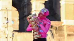 Team UAE's Slovenian rider Tadej Pogacar celebrates his overall leader's pink jersey with the "Trofeo Senza Fine" (Endless or Infinity Trophy) on the podium in front of the Colosseum, after the 21st and last stage of the 107th Giro d'Italia cycling race, 125km from Rome to Rome on May 26, 2024. (Photo by Luca Bettini / AFP)