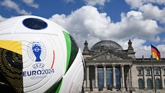 A giant ball of the upcoming UEFA Euro 2024 European Football Championship stands in front of the Reichstag building that houses the Bundestag (lower house of parliament) on June 13, 2024. (Photo by RALF HIRSCHBERGER / AFP)