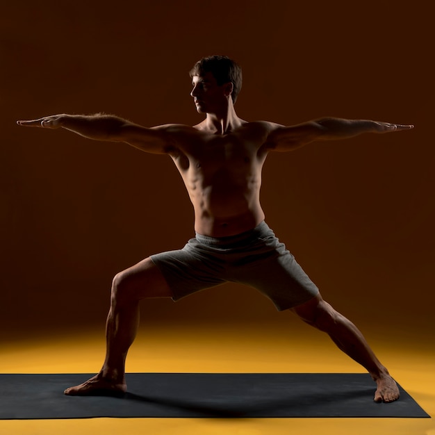 Człowiek ćwiczy pozycje jogi na macie