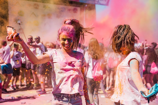 Bezpłatne zdjęcie dwa młodej kobiety bawić się i cieszy się z holi kolorami