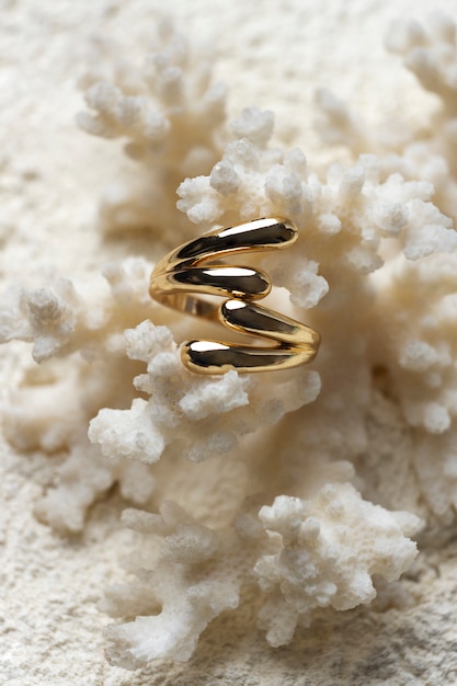 Bezpłatne zdjęcie drogi złoty pierścionek wyświetlany na białym koralowym tle