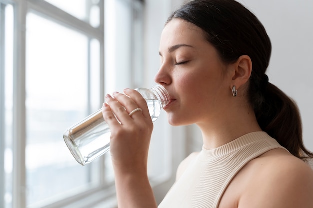 Bezpłatne zdjęcie kobieta pijąca wodę po ćwiczeniach