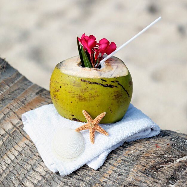 Kokosowy koktajl ze słomką na palmy na plaży