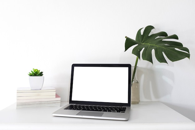 Bezpłatne zdjęcie laptop z pustym białym ekranem na biurowym biurku