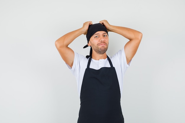 Bezpłatne zdjęcie piekarz, trzymając się za ręce na głowie w t-shirt
