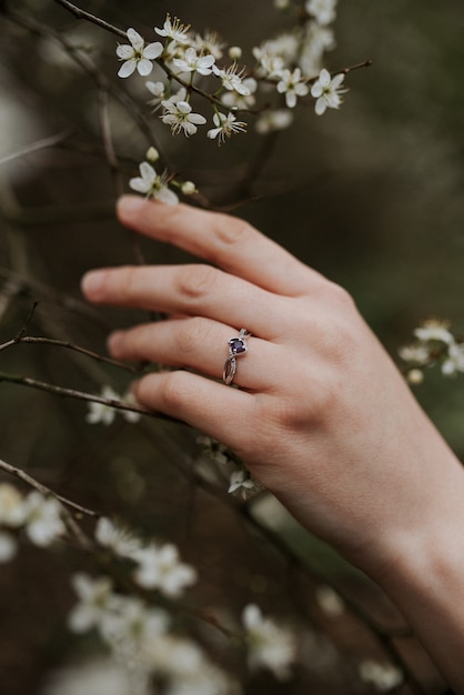 piękny srebrny pierścionek z fioletowym diamentem na miękkiej kobiecej dłoni
