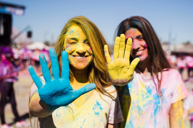 Bezpłatne zdjęcie zakończenie dwa młodej kobiety pokazuje ich malować ręki z holi kolorem