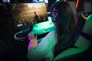 Foto grátis mulher de alto ângulo jogando videogame no computador
