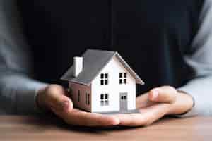 Foto grátis mulher mostrando com uma mão uma mini casa conceito de estado imobiliário ai generative