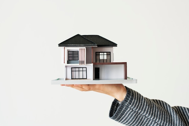 Foto grátis mão apresentando modelo de casa para campanha de empréstimo