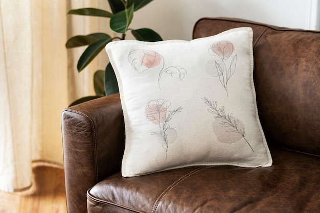 Foto grátis almofada com arte de linha floral mínima em um sofá de couro