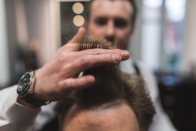 Foto grátis barbeiro turva, preparando-se para cortar o cabelo do homem