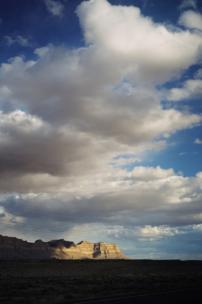 Foto grátis bela foto de um grande deserto com nuvens de tirar o fôlego e montanhas rochosas