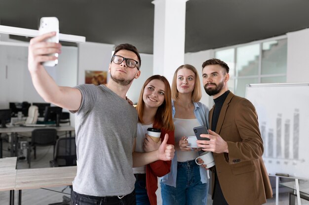 Grupo de colegas de trabalho no escritório tirando uma selfie