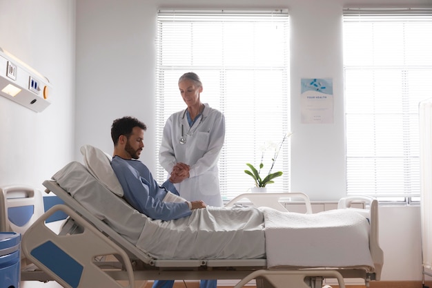 Foto grátis paciente do sexo masculino doente na cama conversando com uma enfermeira