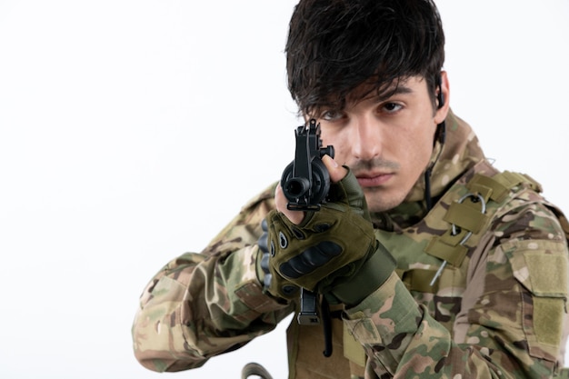 Foto grátis retrato de um soldado em uniforme militar com parede branca de metralhadora