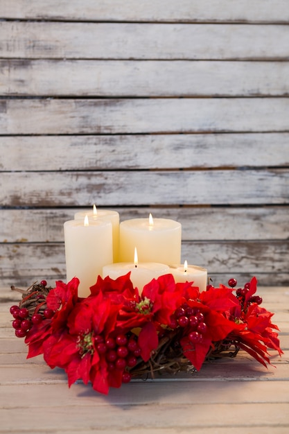 Foto grátis velas brancas iluminadas com flores vermelhas