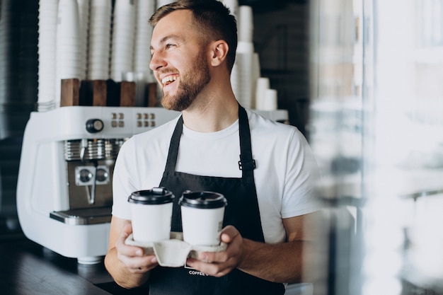Kostenloses Foto männlicher barista mit kaffee zum mitnehmen
