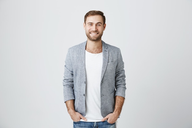 Kostenloses Foto hübscher männlicher unternehmer, der fröhlich lächelt