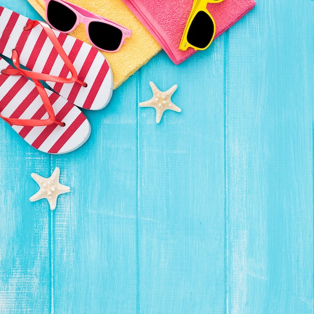 Kostenloses Foto hölzerner hintergrund des ein sonnenbad nehmenden strandes des sommers, sonnenbrille, flipflops, kopienraum