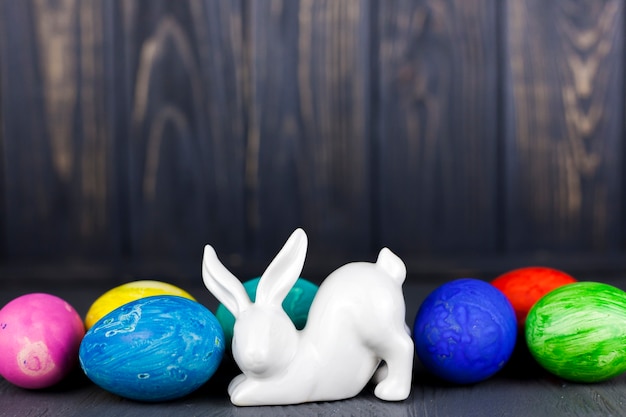 Kostenloses Foto kaninchenstatuette in der nähe von farbigen eiern