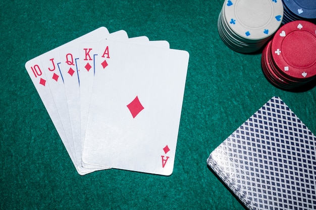 Kostenloses Foto royal flush spielkarten mit casino-chips am pokertisch