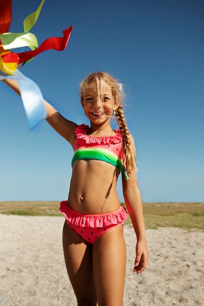 Kostenloses Foto smiley-mädchen der vorderansicht am strand