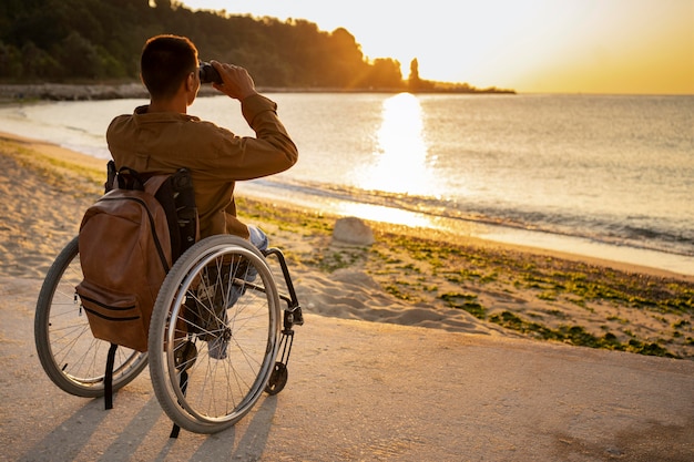 Kostenloses Foto voller schuss behinderter mann mit fernglas