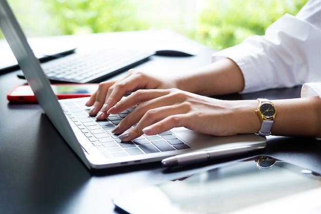 Kostenloses Foto weibliche hand, die auf tastatur des laptops schreibt