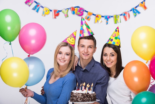Foto tres jóvenes amigos divirtiéndose en la fiesta de cumpleaños.