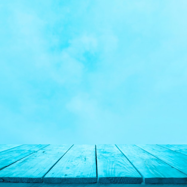 Foto vacío de la mesa de madera azul sobre fondo de cielo suave para la exhibición de productos de montaje.