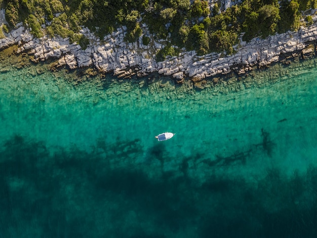 Vista aérea de un pequeño velero atracado en Otok Zavinac Veli