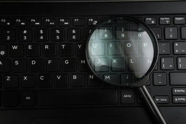 Foto vista de ângulo alto de lupa no teclado do laptop